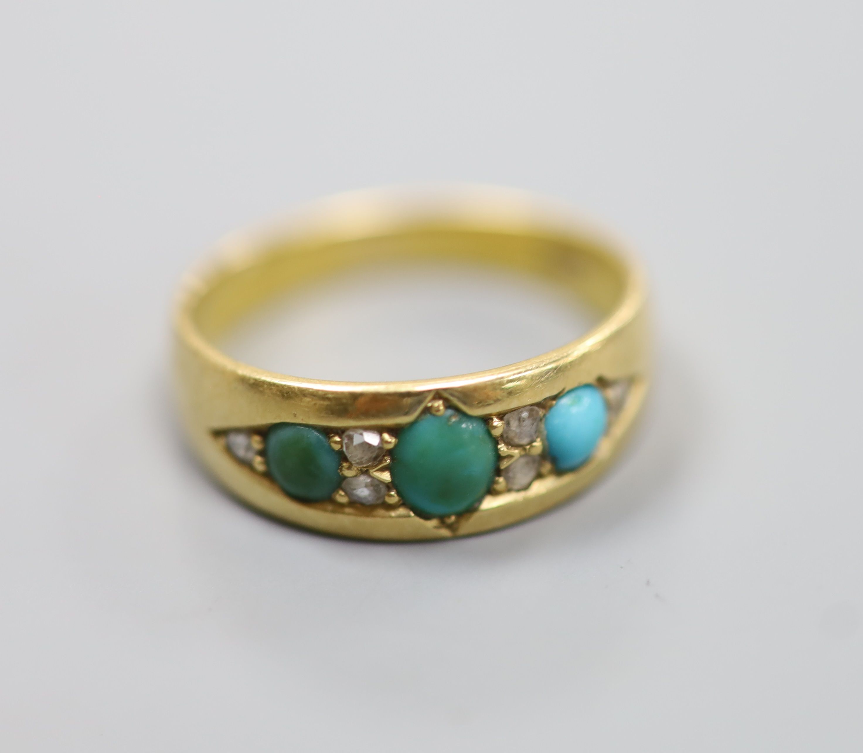 An early 20th century 18ct, three stone turquoise and six stone diamond chip set ring, size M/N, gross 4 grams.
